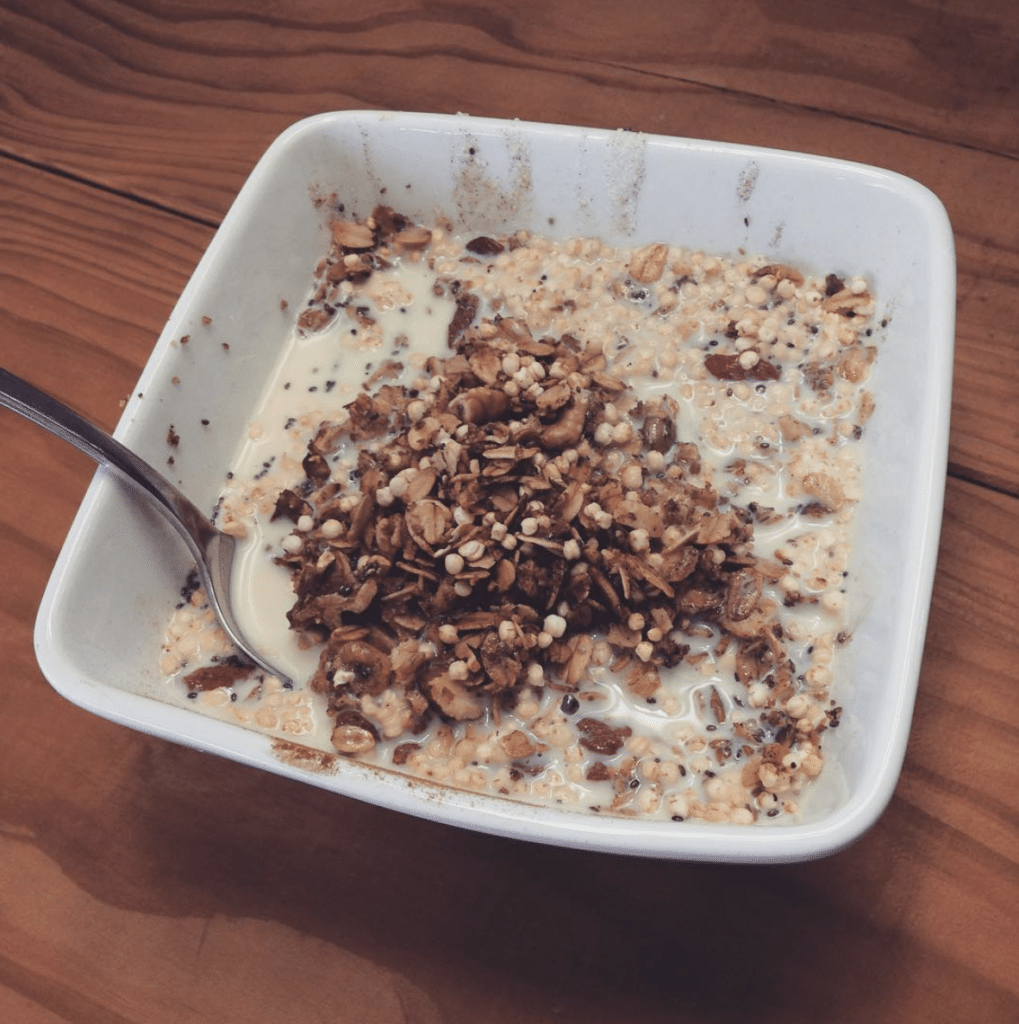 grain free granola topped with almond milk served in a white bowl
