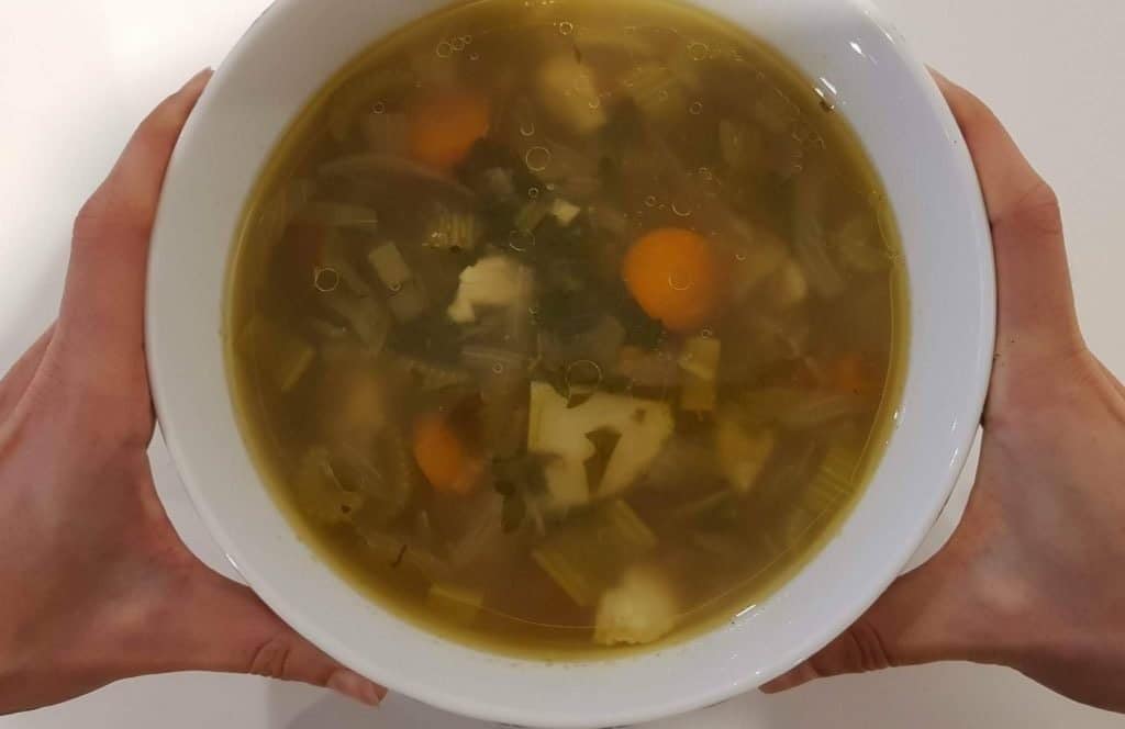 homemade vegetable soup broth yeast free in a white serving bowl