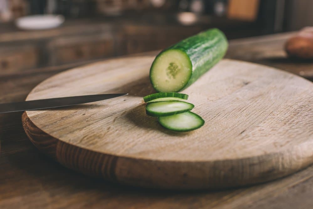 sliced cucumber on a wooden chopping board